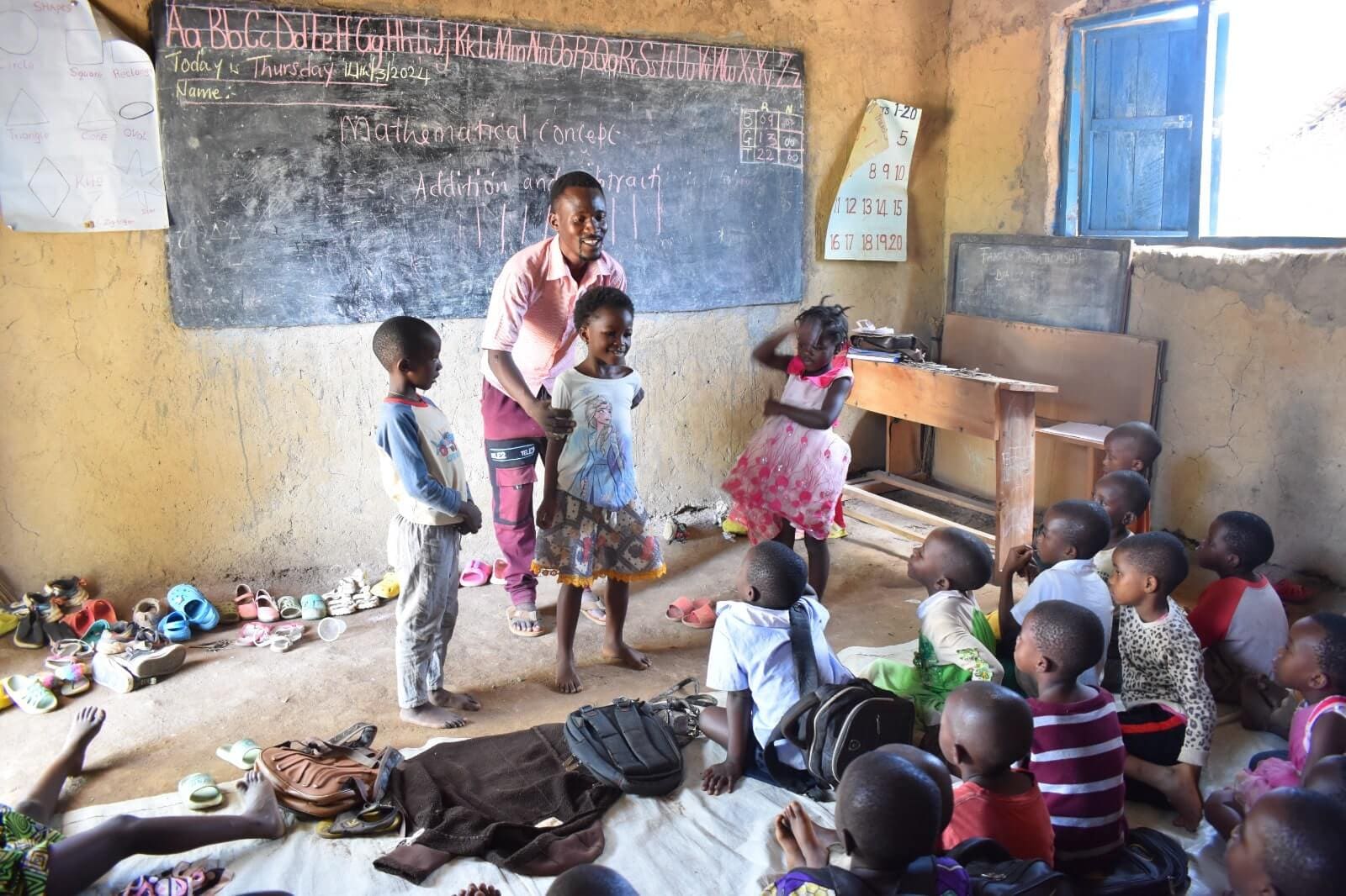 Bruno Tumwekwase interacts with children in class. He believes that attending ECD prepares a child for successful school life