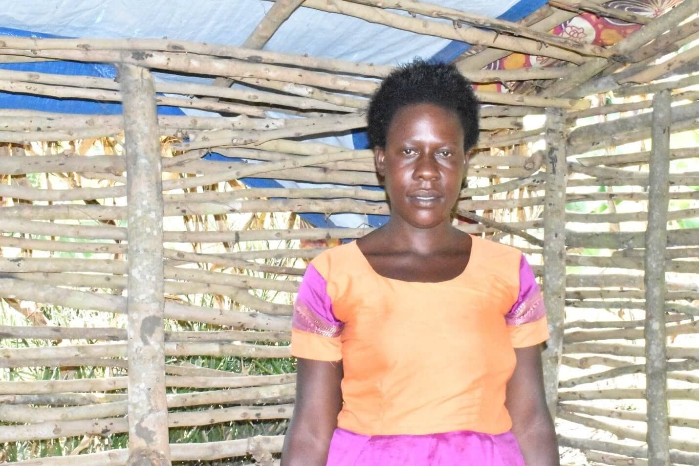 Enid Kukunda inside the Tukwatanise Group chicken pen. The group is rearing chicken to improve diets for their children, and supplement their household income