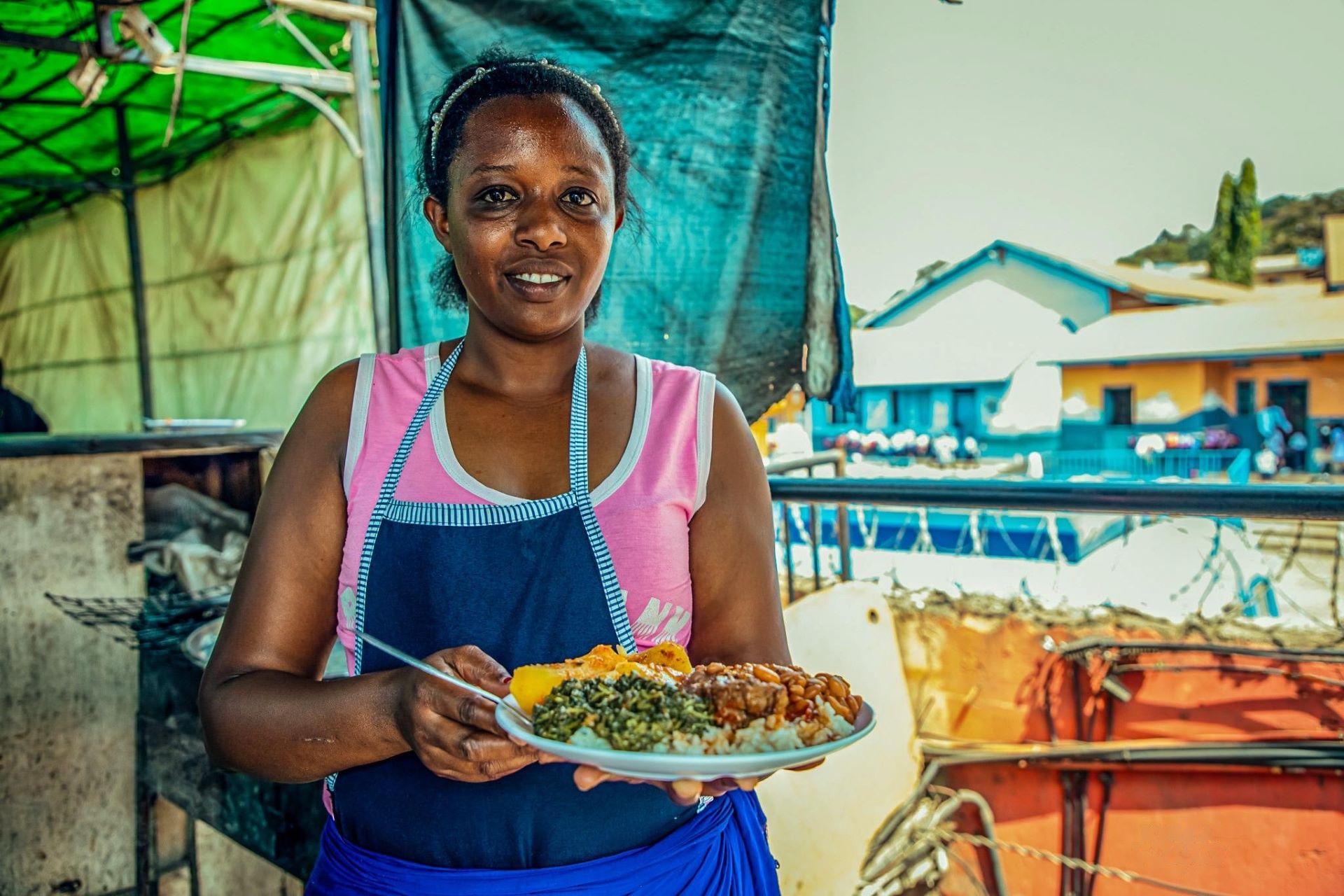 Estella Munezero displays a plate of food shortly before serving a customer. Estella is grateful to the Kulea Watoto Project for supporting her to realize her dream of opening a restaurant in Kampala