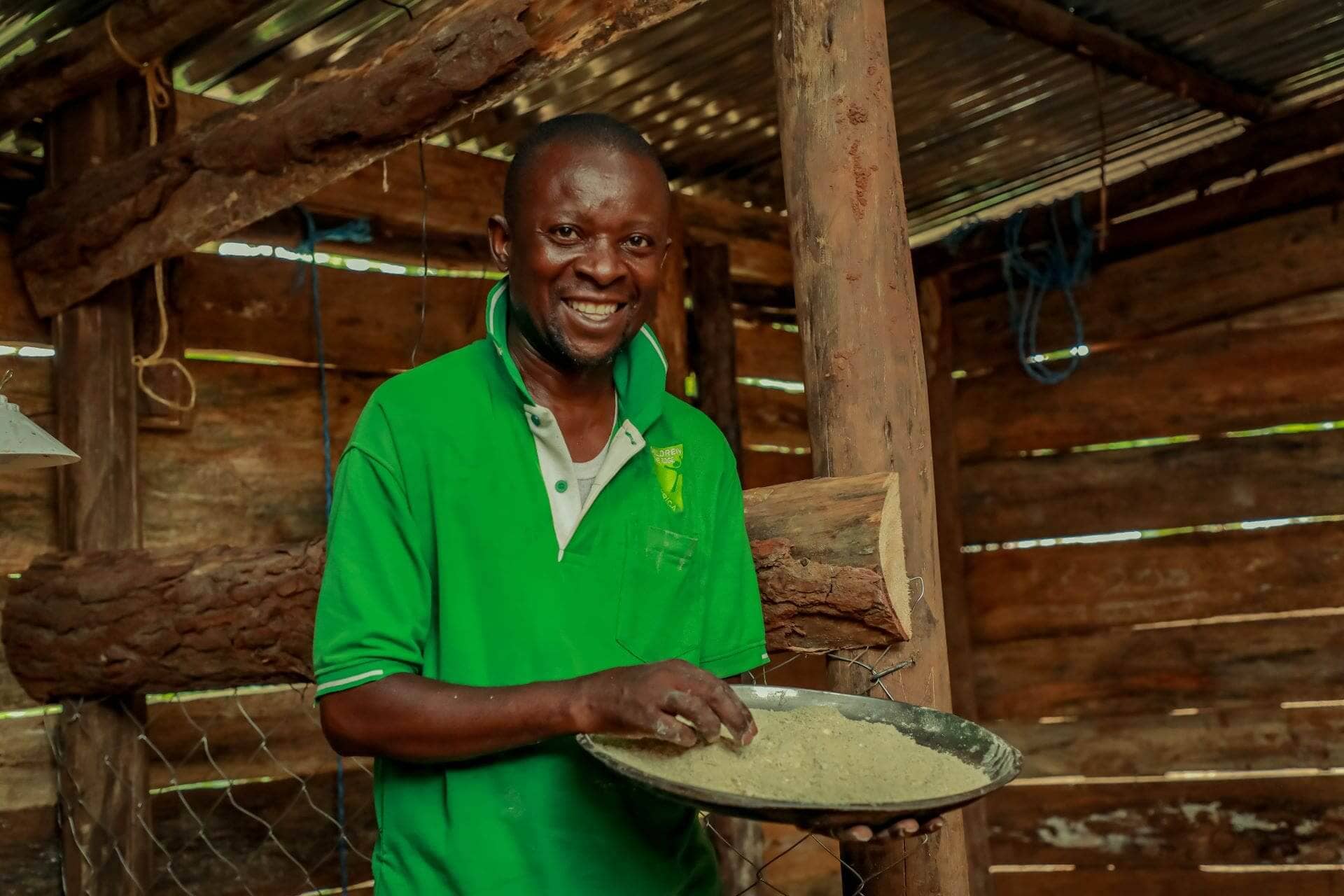 John Byamungu prepares chicken feed for his recently received chicks that he acquired through the seed grant provided by the Kulea Watoto Project