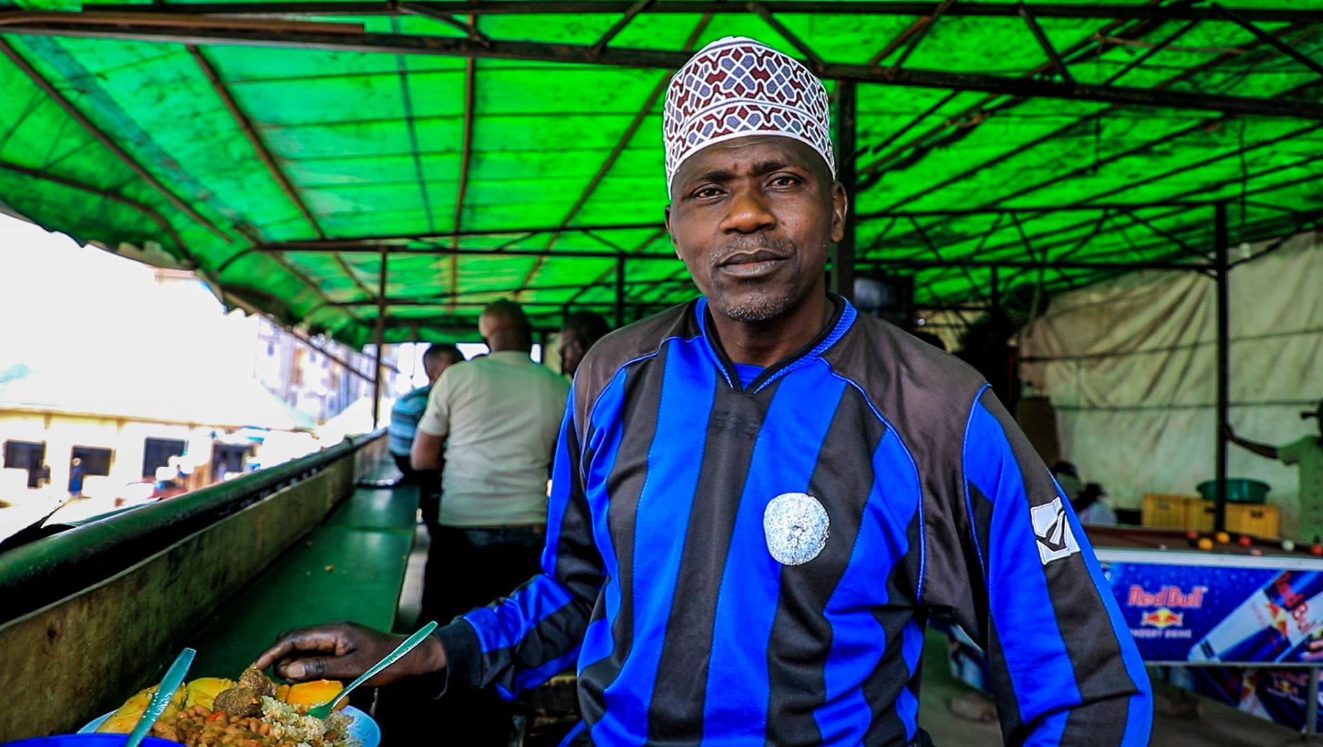 Musa, a regular customer at Munezero’s restaurant enjoys his favorite dish. Musa is thankful towards the Kulea Watoto Project for offering refugees like Munezero cash grants that have enabled them start business like this restaurant that he says its “food reminds me of home”