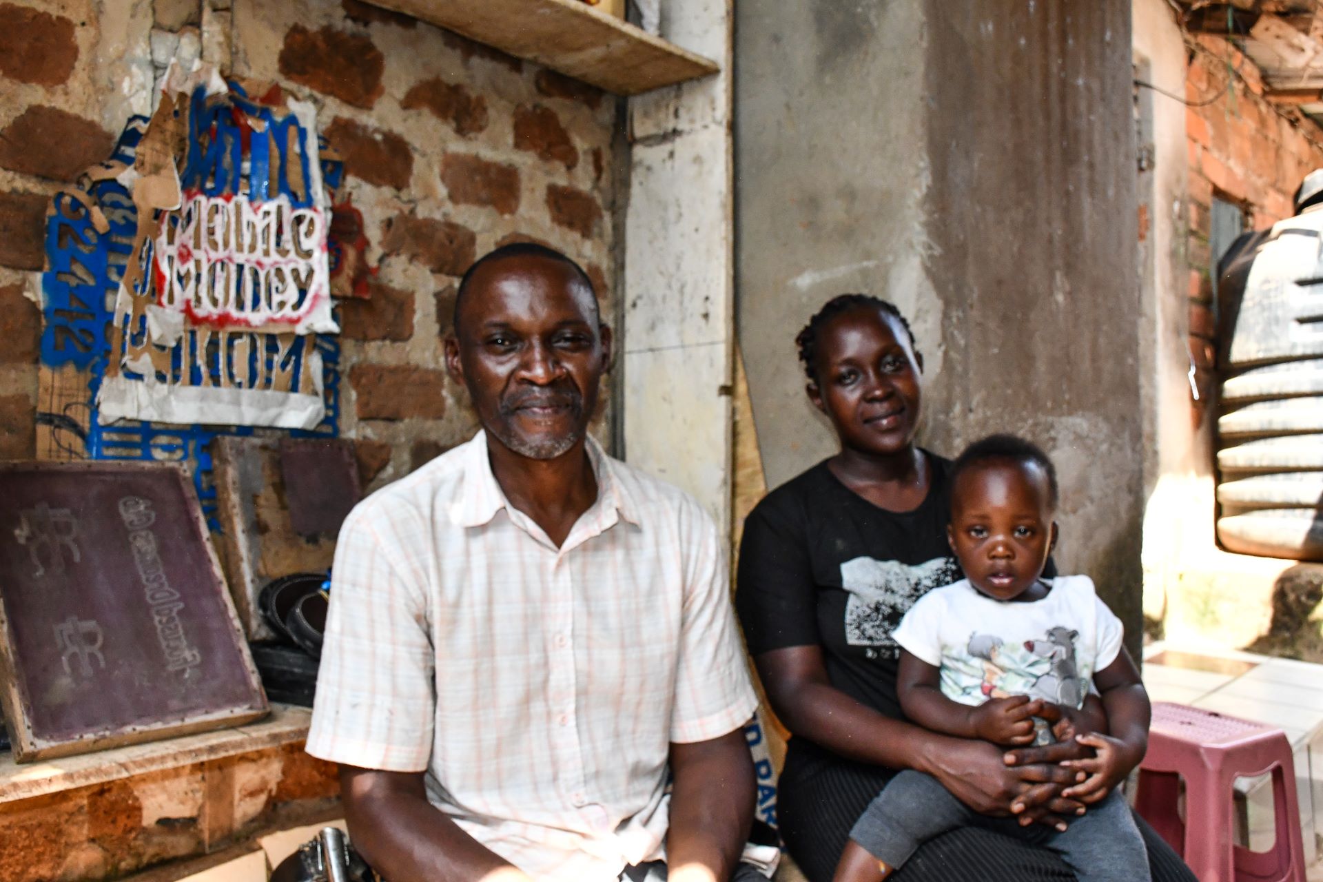 Happy family! Lawrence with his wife Jennifer and son at their home in Lugala. Jennifer is grateful to the Kulea Watoto Project for the support which also enabled her start up a french-fries roadside business that is supplementing their family income