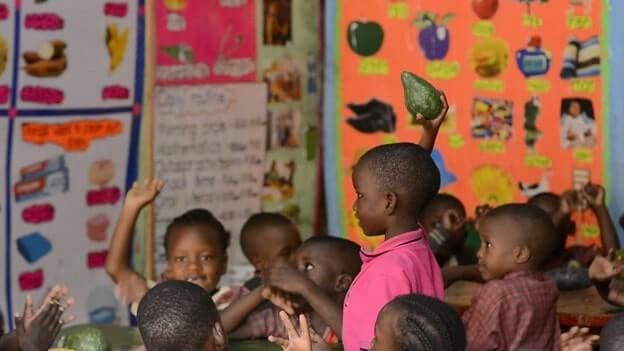 A learner at Shiperoy Nursery and Primary School displays an Ovacado fruit during a class session created out of local materials. Teachers have been skilled in the creation of local play materials by the Kulea Watoto Project