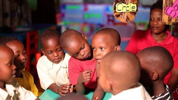Children at Kiti Nursery School in Katwe, Kampala Central, interacting in class as a parent looks on