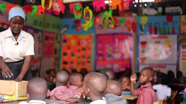 Jauharah Mwesigwa, a lead caregiver at Shiperoy Nursery and Primary School in Lukuli, Makindye division, attends to her learners during a class session