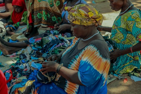 Rukia Mata crafts a ball out of fabric scraps at Mungufeni Home Learning Center. She is grateful for the support in starting up the learning center as it has given chance to their children to have early education essential for a good start in future learning