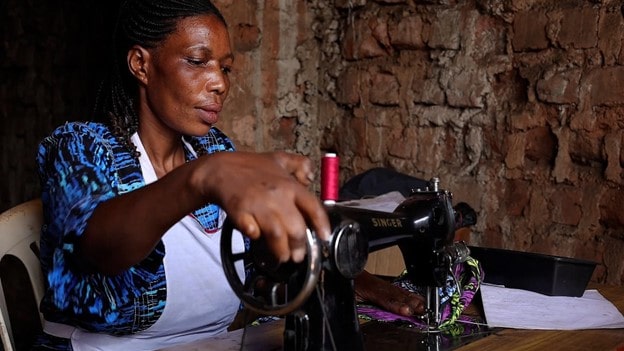 Scovia Kyalisima proudly shows off her sewing skills that have been realised with funding from the Kulea Watoto Project