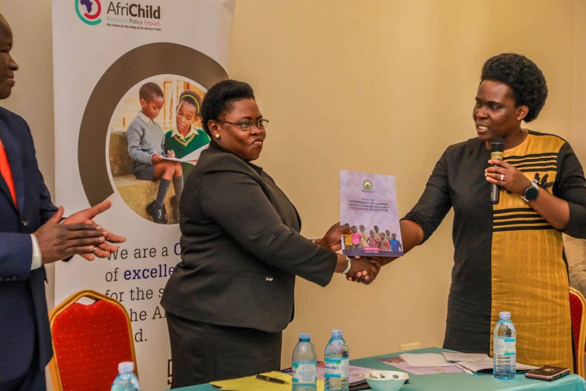 The Chairperson of the Parliamentary Forum for Children, Hon. Margaret Makokha, hands over a copy of the Issues Paper on ‘Why Government of Uganda needs to Prioritize Early Childhood Development’ to Hon. Min. Joyce Kaducu. (Photo by Jonathan Ssekitondo for the IRC)